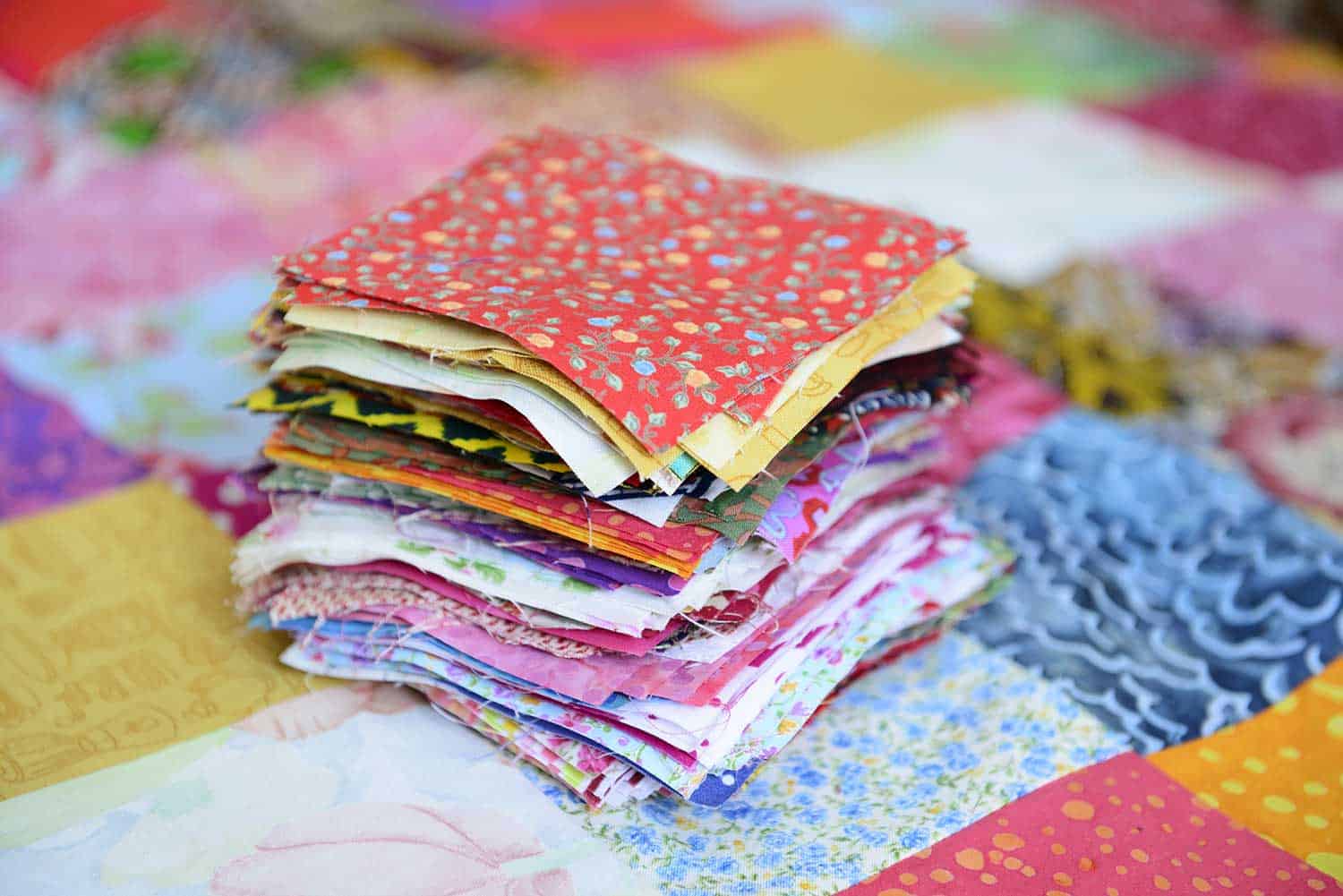 Pile of different colour and patterned material patches for a patchwork quilt