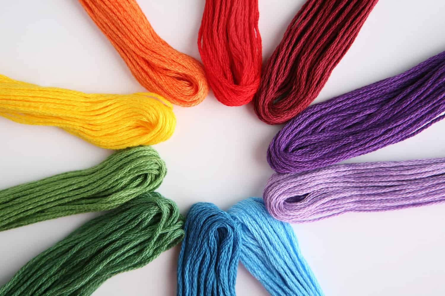 Different colored threads on a white background