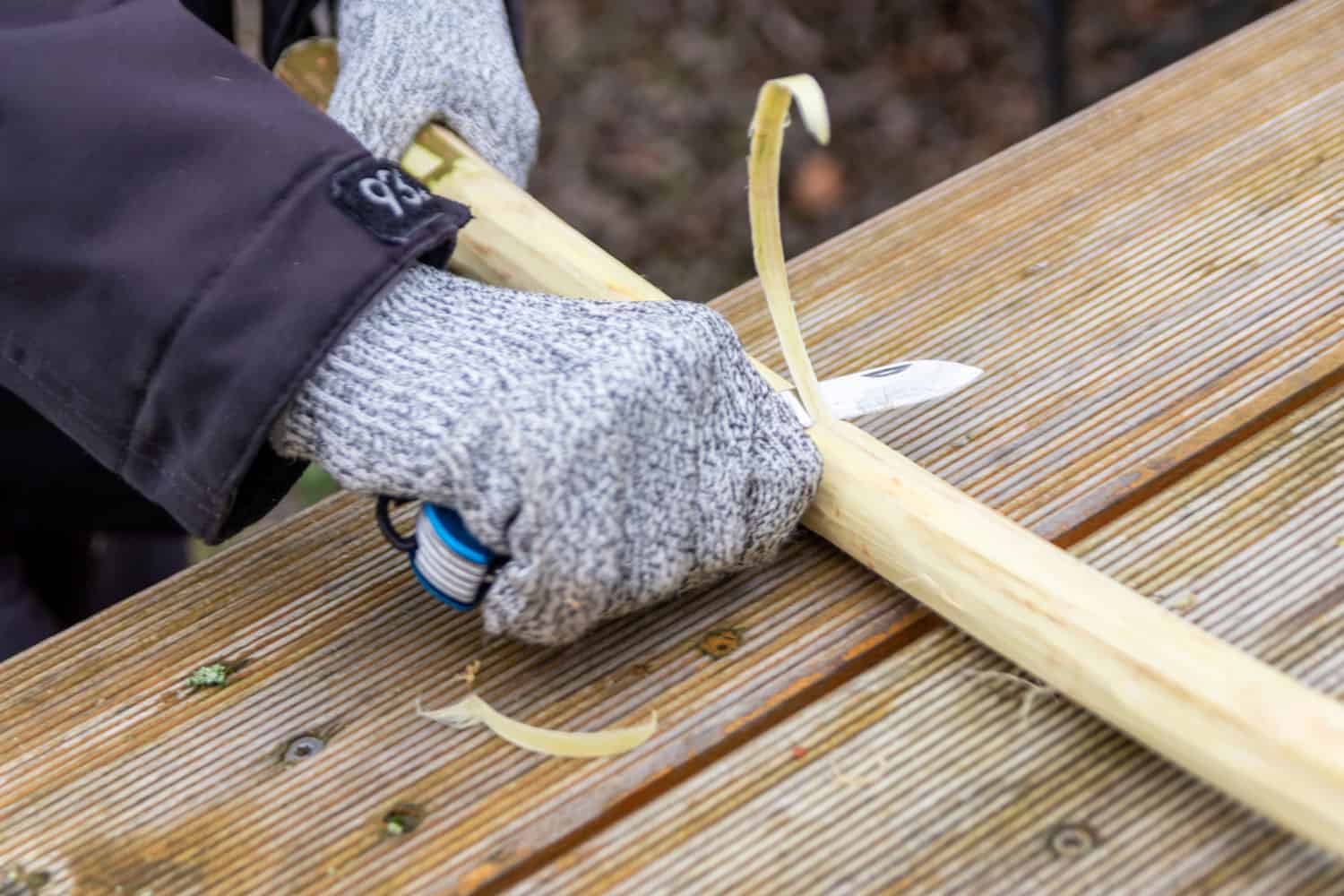 A worker wearing protective gloves while working on his wood working project