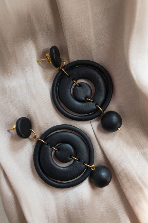 A homemade black colored polymer clay earring