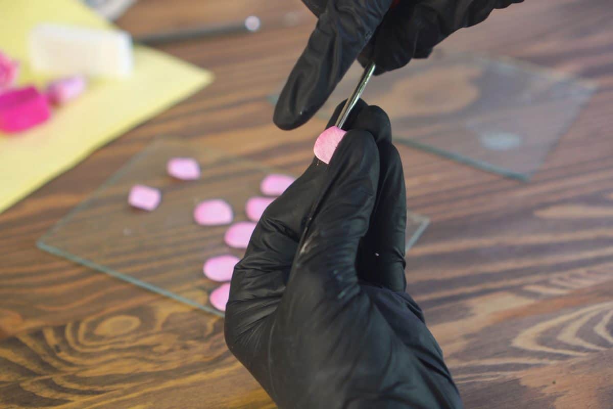 A man wearing gloves doing a polymer project on top of the table