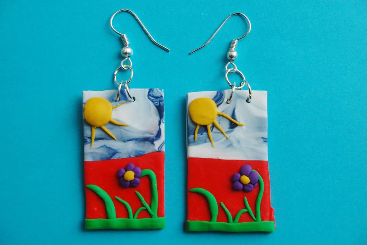 A nature themed polymer clay earring design on a blue background