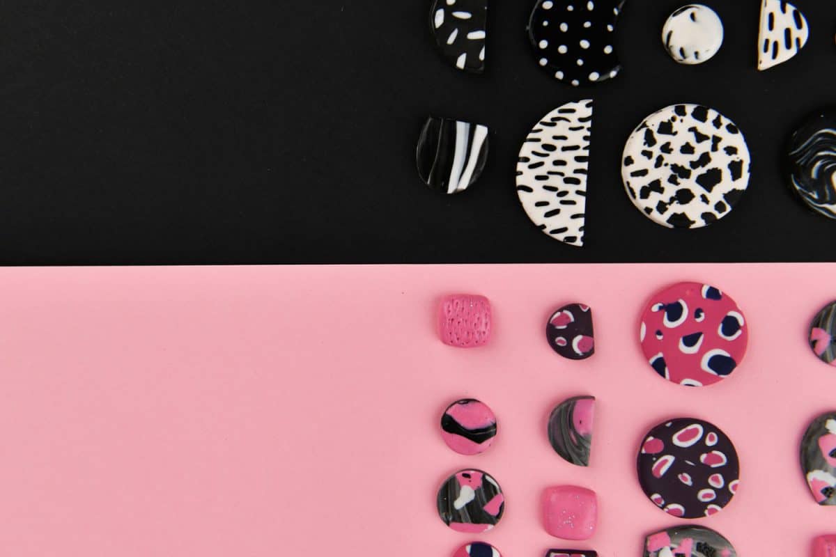 Ornamental designed earrings on a black and pink background
