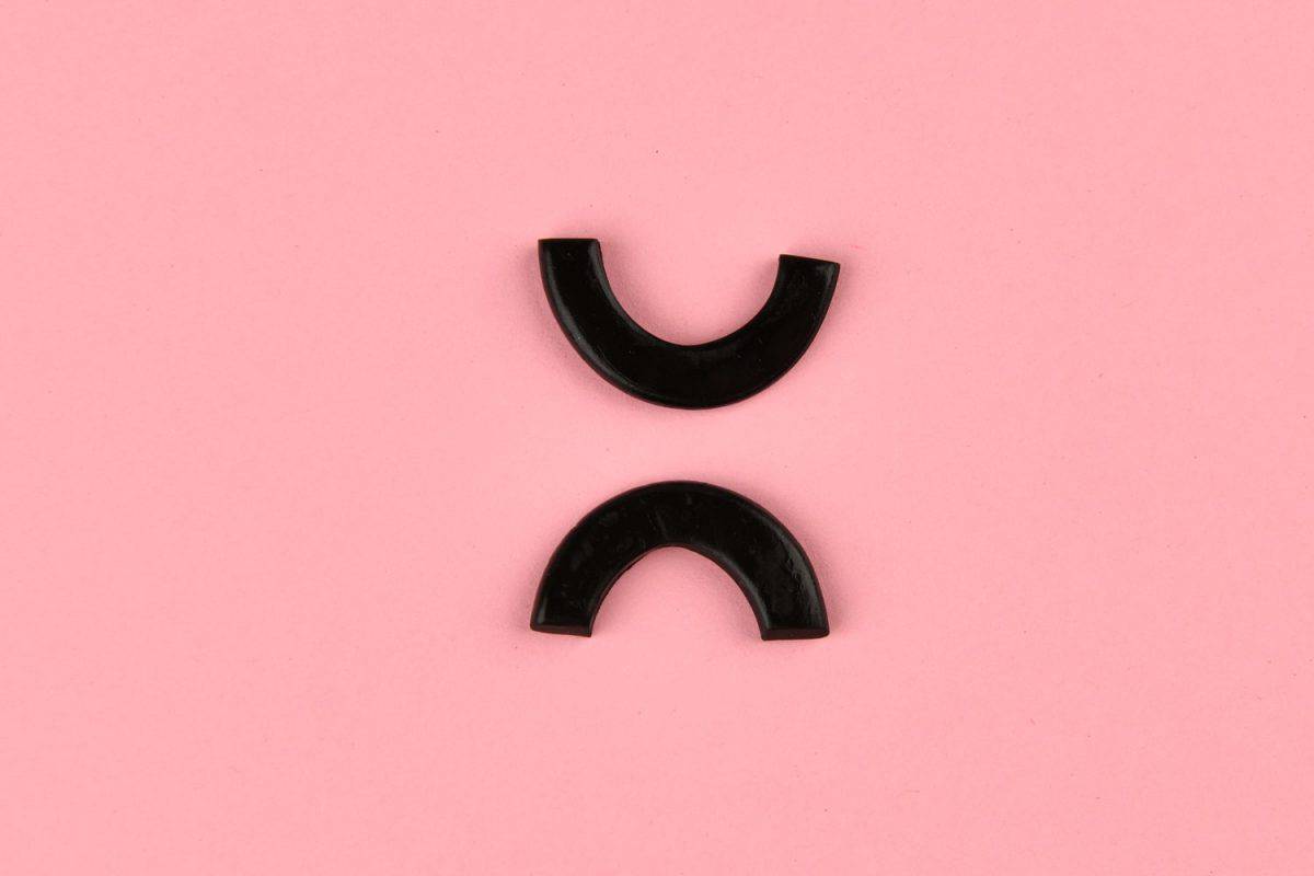 U-shaped earring designs on a light pink background