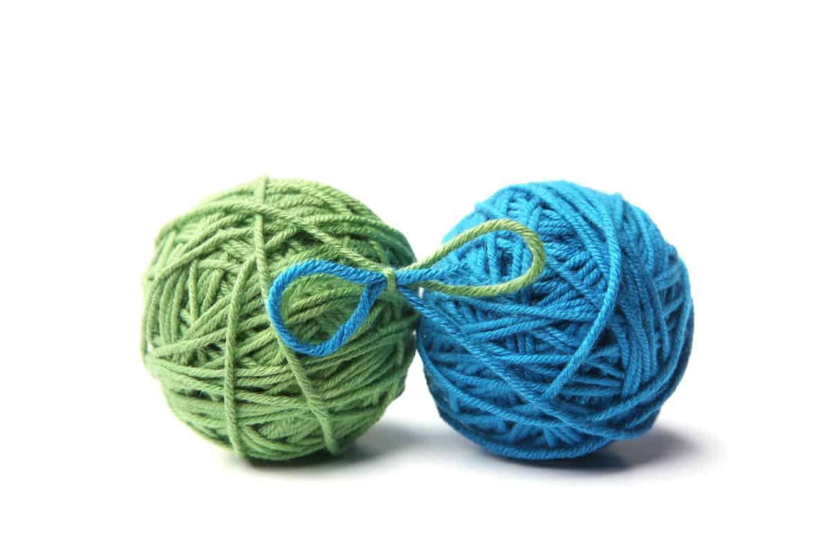 A green and blue colored yarn on a white background