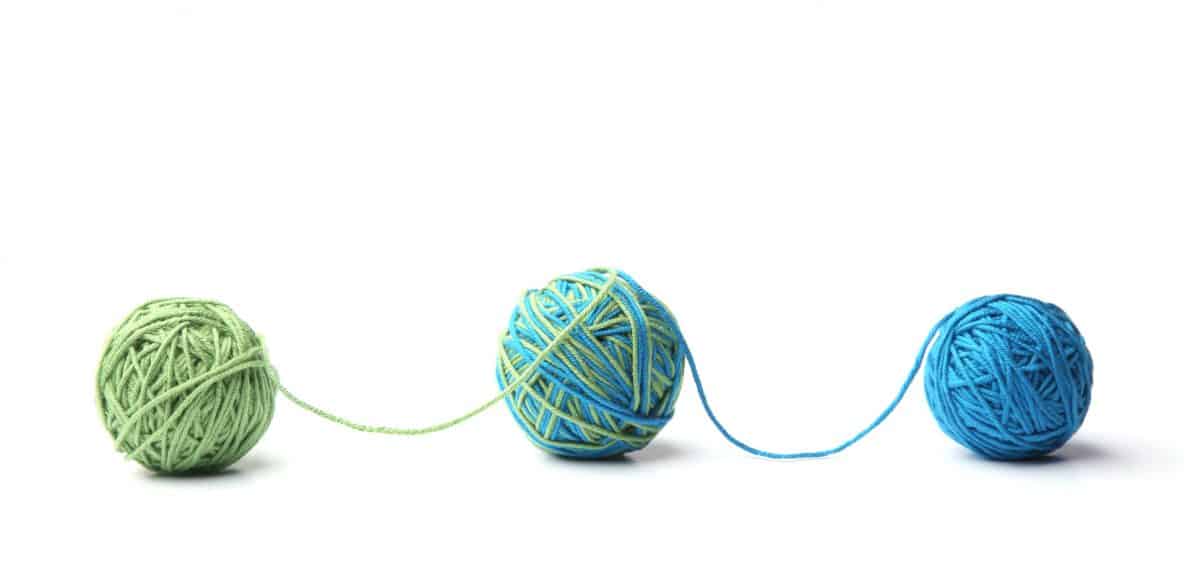 Two balls of yarn mixed together on a white background