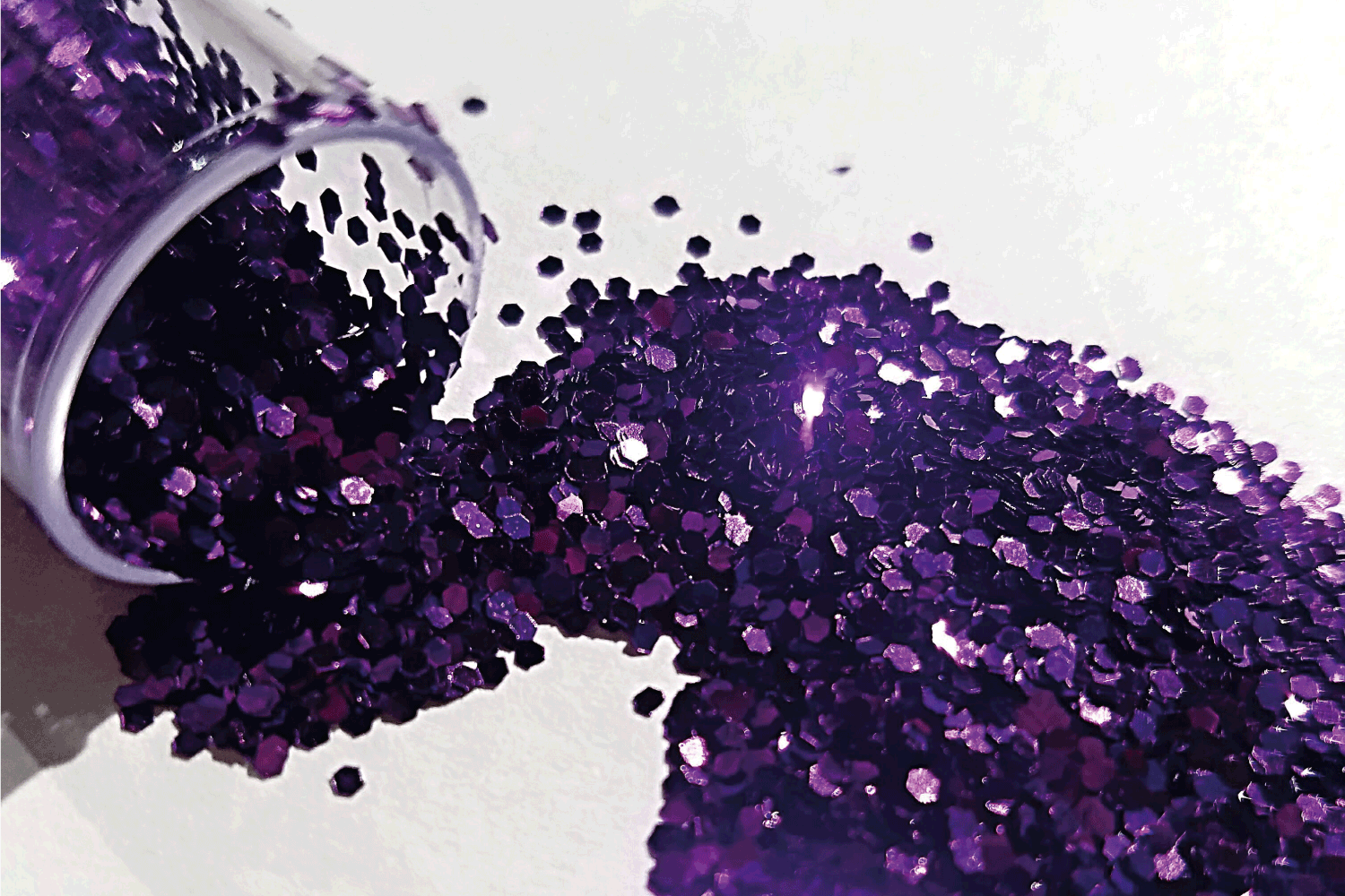 image of purple glitter spilled over a white background