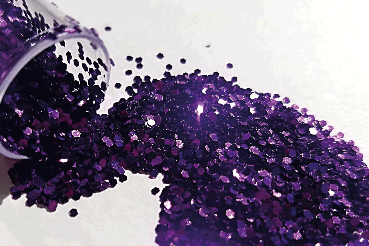 image of purple glitter spilled over a white background