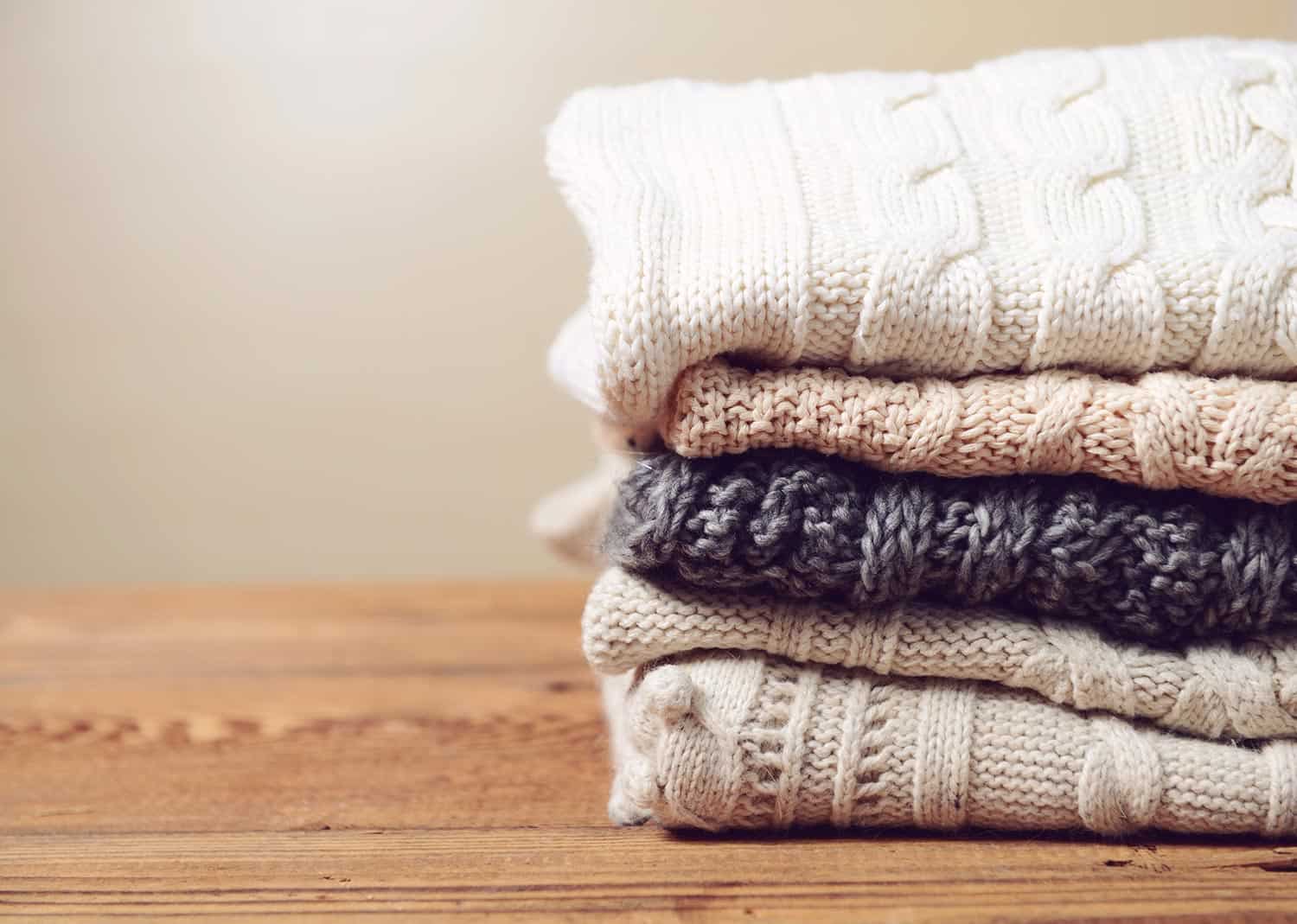Stack of sweaters on a wooden table