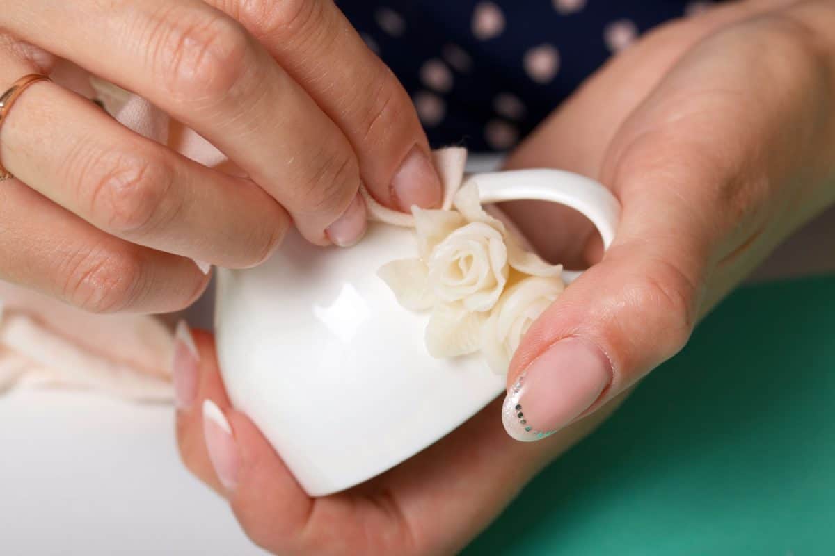 A woman making a flower out of polymer clay