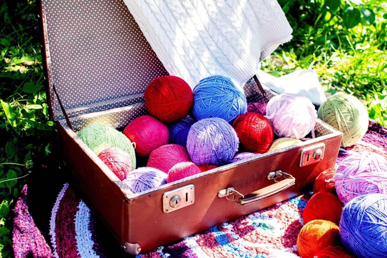 Balls of colored multicolored yarn in an old suitcase