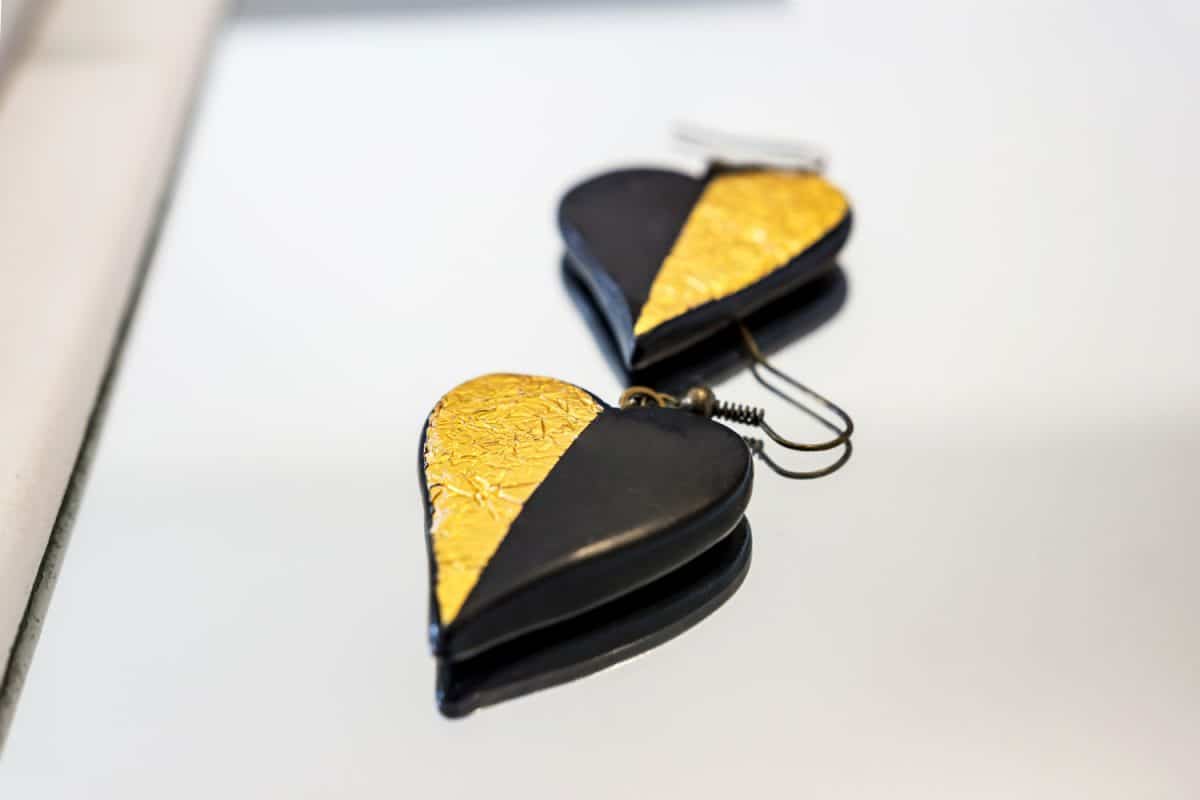 Close-up of handmade Fimo earrings inspired by love, delicate shapes and the everlasting combination of black and gold. Shallow depth of focus.