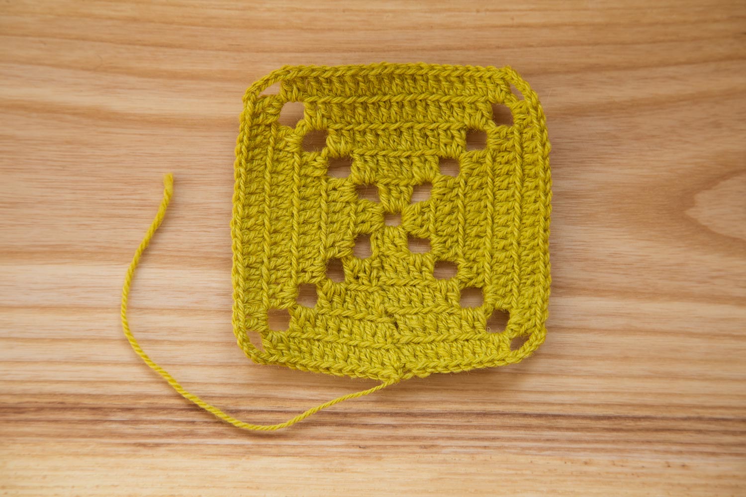 A beautiful hand crocheted pattern pieces of vibrant color gradient in green