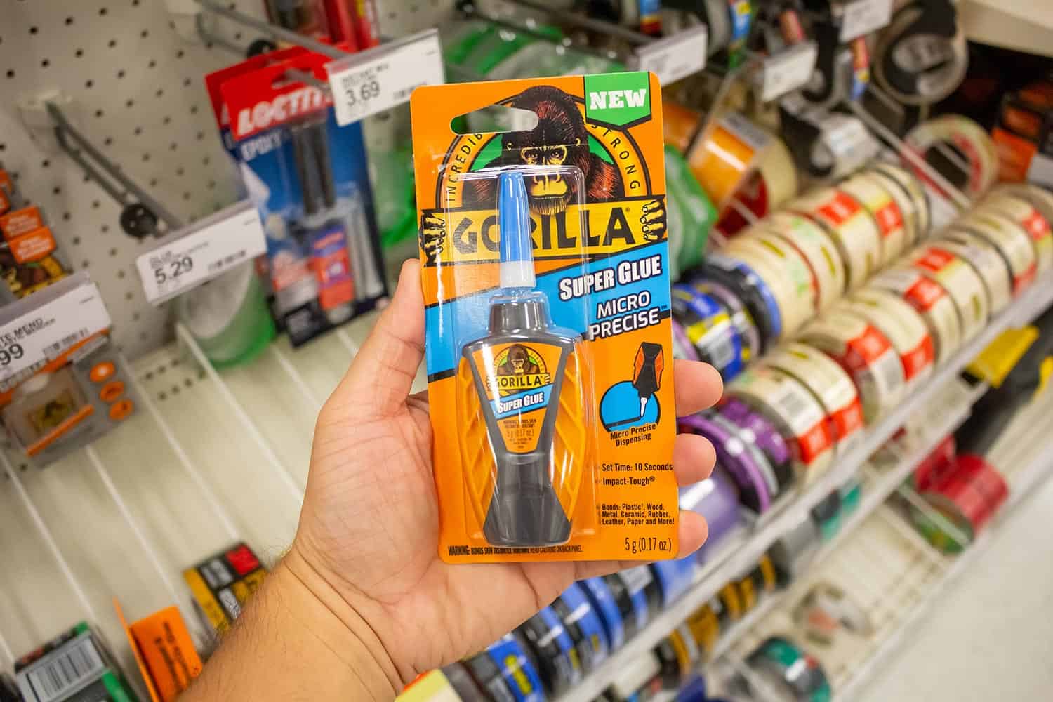  A hand holds a package of Gorilla super glue at a local department store