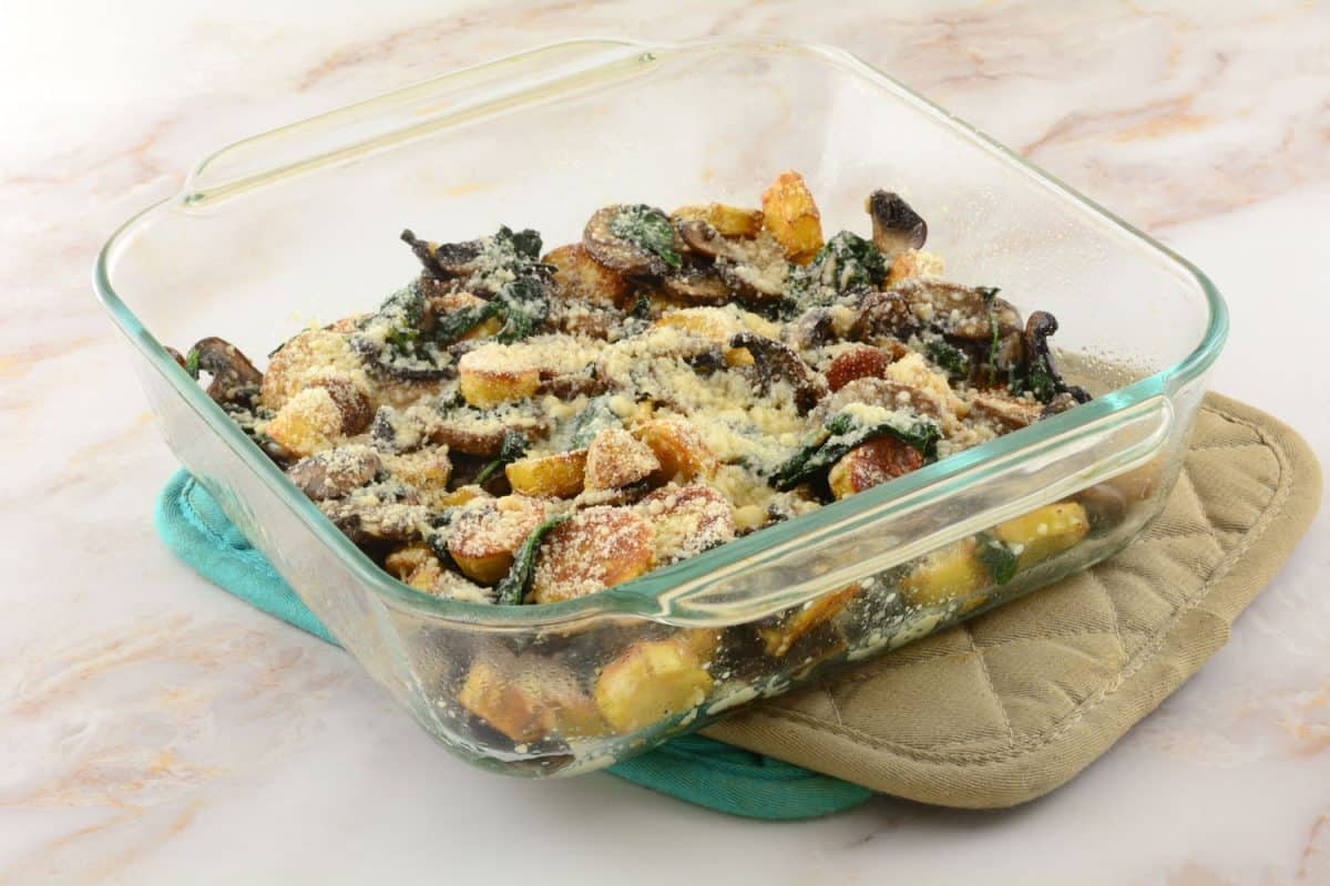 Cheese casserole of potatoes, spinach, and mushrooms on the table