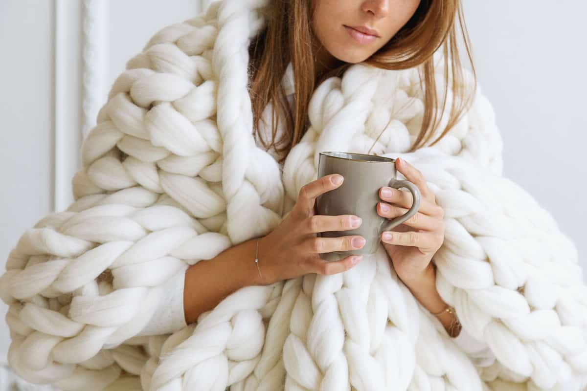 woman covered with chunky merino wool blanket