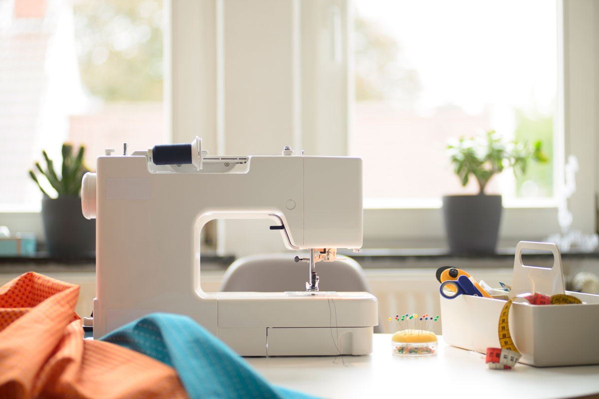 A sewing machine on the table next to different colored fabrics