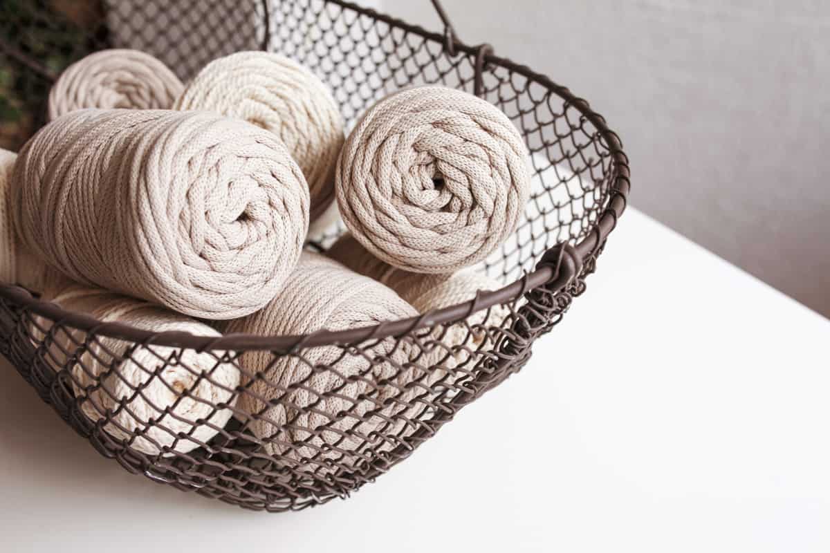 Handmade macrame braiding and cotton threads in basket